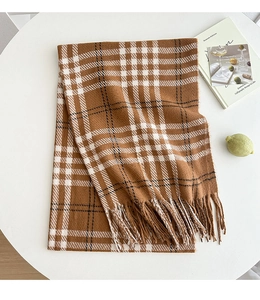 Detail of checkered scarf with long tassels and thick cashmere texture in caramel brown