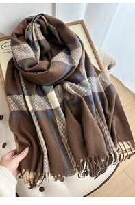 Close-up of thick plaid scarf texture with soft fringe and warm cashmere-like fibers