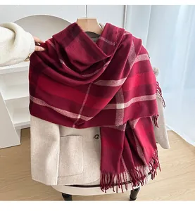 Detailed close-up of thick red plaid scarf with soft texture and long fringe tassels