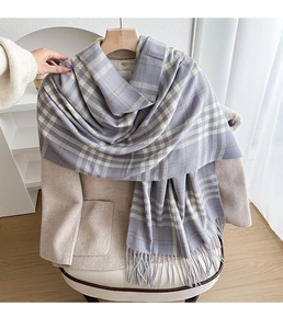 Detailed texture of purple and cream plaid scarf with fringe on a white chair