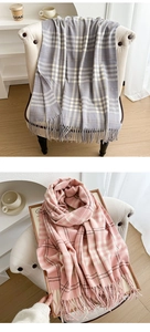 Close-up of thick plaid scarves with tassels in grey-blue and light pink colors
