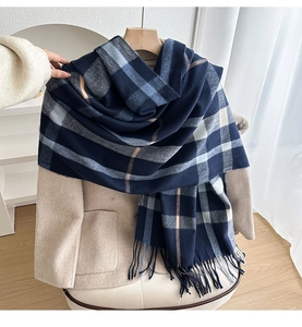 Close-up of thick plaid scarf in navy blue and grey with soft tassel fringe details