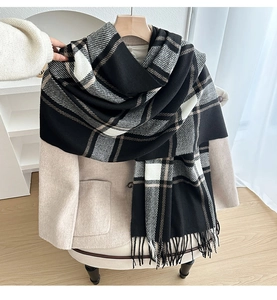 Detail of soft thick plaid scarf with tassels on a wool coat for autumn and winter look