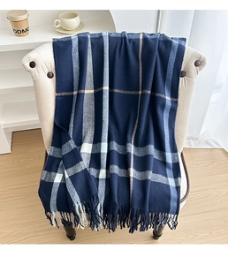 Detail showing soft cashmere-feel navy blue plaid scarf with elegant fringed edges