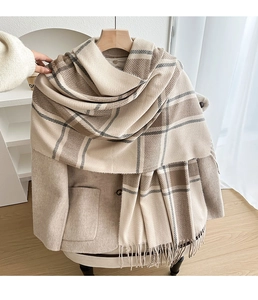 Detailed close-up showing the soft fringe and woven texture of the plaid winter scarf