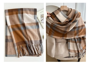 Detail of winter thick checkered scarf with tassels in brown, beige and white tones