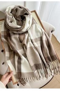 Detailed texture of thick brown and white plaid scarf with fringe on wooden tray
