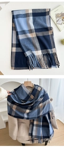 Detail of a thick plaid scarf with tassels, styled on a beige winter coat and flat lay