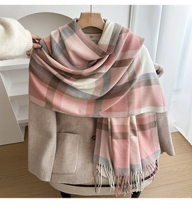 Detailed close-up of pink and grey plaid scarf texture with soft fringed edges