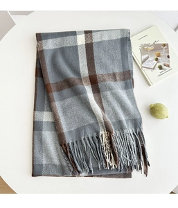 Close-up of thick plaid scarf in grey and brown with elegant fringe details