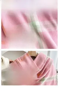Detailed texture of pink plaid cashmere-like scarf with soft fringe and knit pattern