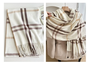 Detailed close-up of British style plaid scarf with soft fringe tassels and thick knit texture