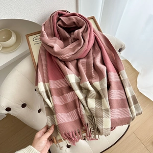 Pink and beige checkered scarf with tassels draped elegantly on a modern white chair