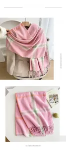 Detail of pink plaid imitation cashmere scarf with soft fringe on beige coat and table