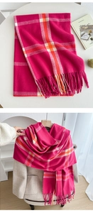 Detailed macro view of bright fuchsia plaid tassel scarf with soft cashmere-like texture