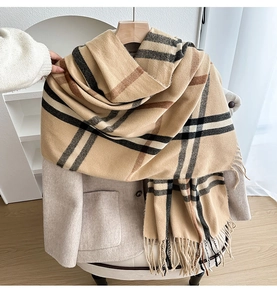 Detailed view of classic khaki plaid scarf styled with a warm wool coat and fringes