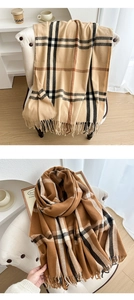 Detailed view of British plaid scarves with tassels in classic beige and caramel colors