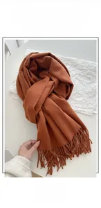 Detail shot of soft orange-brown cashmere-feel fabric with matching tassel fringes