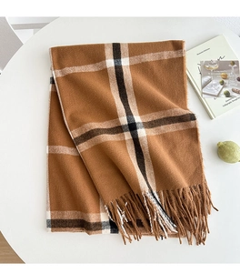 Detail of plaid scarf with fringe texture on a white decorative setting for winter