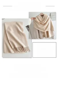 Close-up of soft beige winter scarf featuring delicate fringe tassels and knit texture