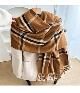Detail of classic brown plaid cashmere scarf with soft fringes on beige coat