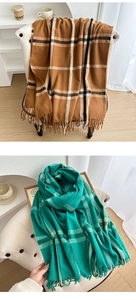 Detail of soft cashmere-feel scarves in camel and green plaid with elegant fringe edge