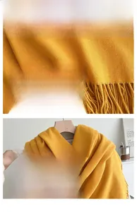 Detail of ginger yellow knitted scarf showing soft cashmere-like texture and tassel edges