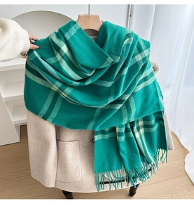 Detail of dark green checkered cashmere scarf with long tassels on a beige blazer