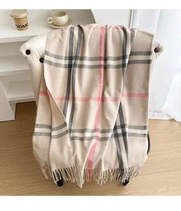 Detail of soft cashmere-like beige scarf with grey and pink plaid pattern and fringe