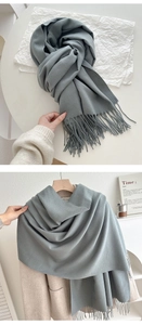 Detail of soft morandi grey scarf with fine knit texture and decorative tassels