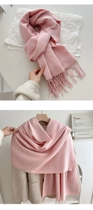 Detail of pink tassel scarf texture showing soft pashmina material and fringe craftsmanship