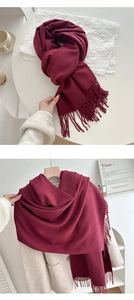 Close-up of wine red cashmere-feel scarf tassels draped over a beige winter coat