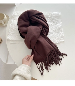 Detail of soft dark brown cashmere-like scarf showing thick knit texture and long tassels