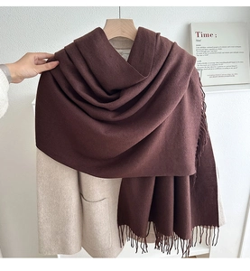 Detail of soft dark brown cashmere-like scarf with long tassels and thick texture