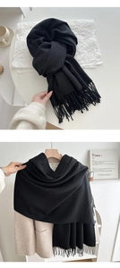 Close-up of black cashmere-like scarf with long tassels and thick warm winter texture