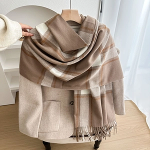 Classic plaid winter scarf with fringe tassels shown on a minimalist coat hanger