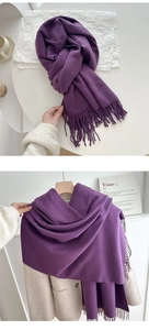 Detail of dark purple tassel scarf draped over a beige wool coat for winter styling