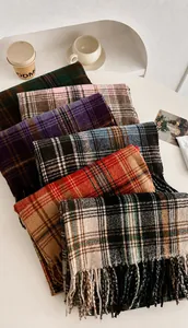 Detail verschiedener karierter Schals mit Fransen für den Winter auf einem Tisch