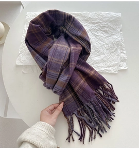 Makroaufnahme eines dicken violetten Vintage-Karo-Schals mit Fransen auf weißem Papier