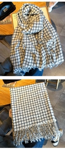 Dettaglio della sciarpa in maglia a quadretti neri e bianchi con rifiniture a frange
