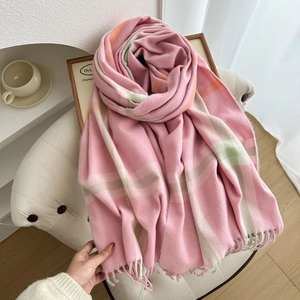 Pink plaid cashmere-feel scarf with soft tassels draped on a modern armchair