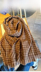 Vue détaillée de l'écharpe en maille à motif pied-de-poule avec texture douce style cachemire