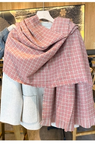 Gros plan d'une écharpe à carreaux rose et blanc avec franges sur un manteau