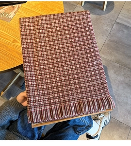 Détails du tricot de l'écharpe à carreaux rouges et blancs avec de larges franges décoratives