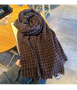 Gros plan d'une écharpe en tricot à carreaux rouges et noirs avec détails de franges