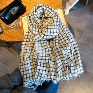 Sciarpa classica pied-de-poule bianca e nera con nappe su elegante tavolo in legno
