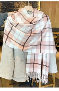 Detail eines rosa-weißen Karoschals mit Fransen, kombiniert mit einem beigen Wintermantel