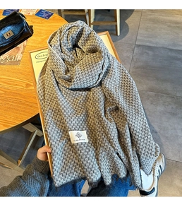 Λεπτομέρεια γκρι κασκόλ με υφή houndstooth και την ετικέτα της μάρκας VE.BLOSSOM