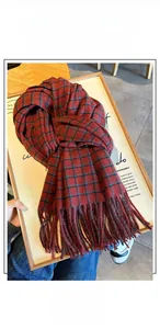 Detail of red and dark green plaid cashmere-feel scarf featuring dense fringe tassels