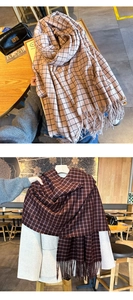 Detail of red and pink plaid scarves with fringe tassels in a cozy cafe setting